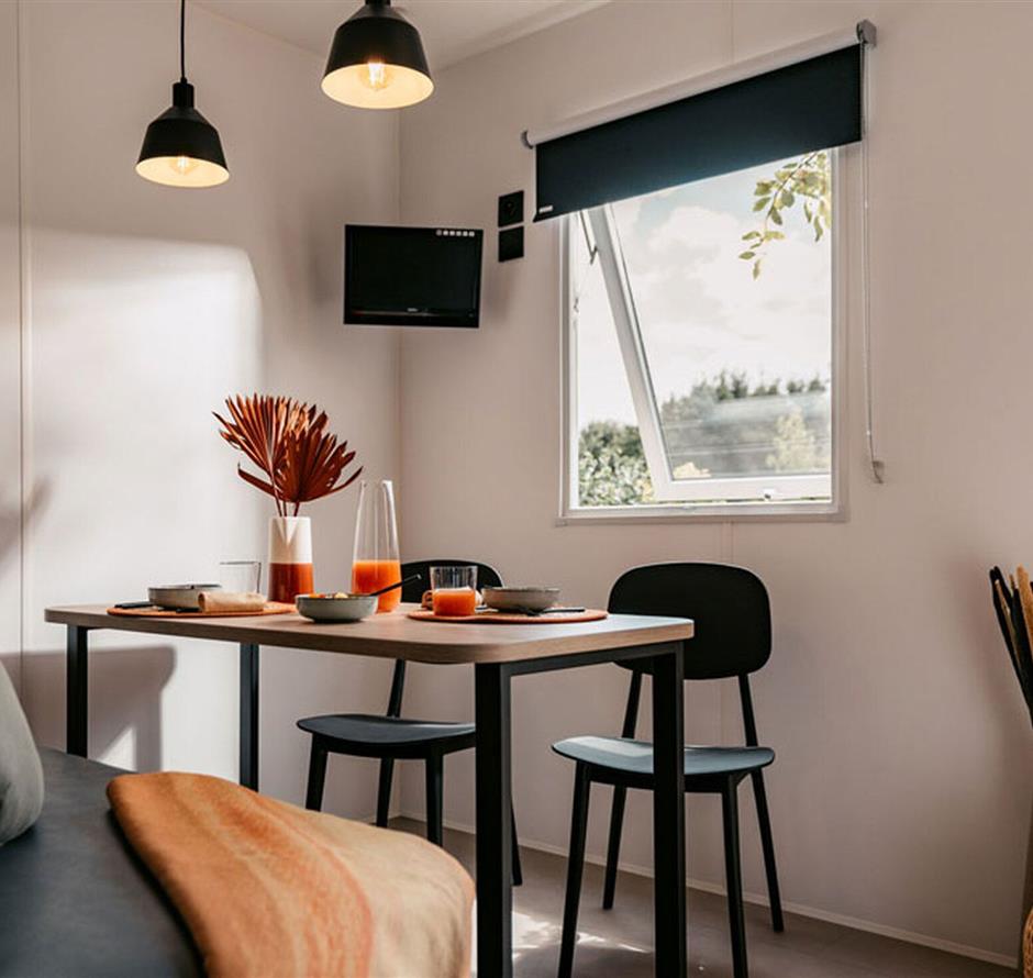 Salon avec canapé et table dans un cottage IRM 5* - Camping Saint Hilaire de Riez